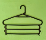12 cabides de plástico preto com 3 travessas para calças e ganchos para blusa ou saia. 32 x 41 cm. Com suporte organizador de plástico branco.