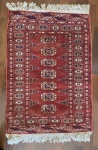 Tapete Oriental ao estilo Boukhara, fundo predominante vermelho com desenhos pata de elefante. 90 x 62 cm ou 0,55 cm