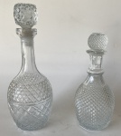 Lote composto de 2 garrafas de vidro translúcido com acabamentos e tamanhos diferentes. Maior: 8,5 cm de diâmetro na base x 32 cm de altura