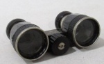 COLECIONISMO - Um binóculos na cor preta confeccionado em materiais diversos, da manufatura AIDA 2,5x30, usado. Medidas 9,5 cm de comprimento x 5 cm de largura.
