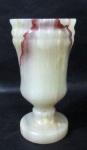 OBJETOS DECORATIVOS - Vaso decorativo esculpido em pedra ônix com nuances bordô e esverdeados, medindo: 18,5 cm de altura x 9,5 cm de diâmetro.