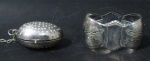 METAL PRATEADO - Duas peças em metal espessurado a prata, sendo um coador de chá e um porta guardanapo com decoração em perolados e acantos em relevo. Medidas: maior: 3,5 cm de altura x 5,5 cm de comprimento/ menor: 5 cm de comprimento.