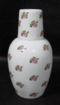 PORCELANA - Moringa com copinho em porcelana vitrificada branca, delicadamente decorados com flores e folhas. Medidas: moringa: alt total 15,5 cm/ copo: alt 4,8 cm x diam 4,5 cm. Copo com ínfimo bicado na borda.