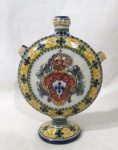 PORCELANA - Um vaso decorativo em porcelana portuguesa vitrificada e exuberantemente policromada, apresenta formato circular, decorado com Brasão de Portugal e motivos vegetalistas, apoiado sobre pé bolacha, assinado no fundo, conforme foto extra. Medidas: alt 18,5 cm x diam da borda 2 cm x diam do bojo 13 cm, aproximadamente.