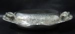 METAL PRATEADO - OLD ENGLISH SILVER PLATE - Uma terrina em metal inglês espessurado a prata, apresenta formato oval, bordas recortadas com rico trabalho cinzelado em relevo de flores, folhas e volutas, marcada no fundo, medindo: alt total 7,5 cm x comp total 33 cm x larg total 26 cm. Possui discretas marcas de uso.