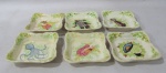 FAIANÇA - Seis porta espinhas de peixe em faiança vitrificada na cor creme, em formato quadrado com cantos repuxados, ornamentados com elementos vegetalizas e frutos do mar em rica policromia, bordas onduladas, medindo: 3 cm de altura x 11,5 cm de largura. Com pequenas falhas na esmaltagem.