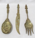 BRONZE - Trio de talheres decorativos em bronze maciço, cinzelado com riqueza de detalhes, apresentando decoração holandesa com cenários de taberna e rural em relevo, sendo: um garfo, uma faca e uma colher. Medidas: maior: 36 cm de comprimento/ menor: 34 cm de comprimento. Possui marcas do tempo.