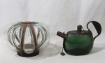 VIDRO - Lote contendo duas peças em vidro com guarnições em metal, sendo uma garrafa para bebida em forma de chaleira na cor verde, e uma cúpula translúcida soprada, conforme fotos. Medidas: garrafa: alt total 14 cm x larg total 21,5 cm/ cúpula: alt 14,5 cm x diam de encaixe 10,5 cm. Com marcas do tempo/ sinais de oxidação.