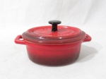 PORCELANA - PETITES CASSEROLES - Uma pequena panela em porcelana vitrificada nas tonalidades vermelha, creme e preta, ao gostos Francês, apresenta formato oval, marcada no fundo. Medidas: alt total 9 cm x comp tptal 17 cm x larg 10 cm. Com marcas de uso no fundo.