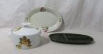 FAIANÇA / PORCELANA - Lote contendo três peças, sendo: A) uma travessa e uma petisqueira com três divisórias, em faiança vitrificada nas tonalidades creme e verde, em formato ovalado, decoradas com elementos vegetalistas e volutas; B) uma sopeira em porcelana vitrificada branca, da manufatura RENNER PORTO ALEGRE, decorada com motivos florais em rica policromia, pega da tampa em formato de disco, bordas filetadas à ouro. Medidas: maior: al total 14,5 cm x diam da borda 20,8 cm/ menor: comp 37,5 cm x larg 19 cm. Travessa e sopeira possui manufaturadas marcadas em suas bases.