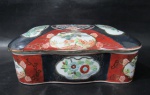 PORCELANA IMARI - Antiga caixa porta joias em porcelana japonesa vitrificada e ricamente policromada, descorda com motivos vegetalistas e zoomórficos realçados à ouro, bordas movimentadas, marcado com selo em caracteres no fundo. Med. alt total 8 cm x comp 20 cm x larg 13,8 cm.