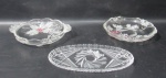 CRISTAIS - Três petisqueiras em cristal translúcido, sendo duas em formato circular e uma ovalada, profusamente lapidadas com folhas, flores, cachos de uvas, cata-ventos e caneluras. Medidas: maior: comp 22 cm x larg 11 cm/ menor: diam 17 cm. Em ótimo estado! Vide fotos!