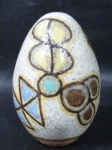 CERÂIMCA - FRANCISCO BRENNAND - Um ovo em cerâmica esmaltada em rica policromia, assinado na base. Medida: 12,5 cm de altura.
