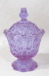 VIDRO - Delicada bomboniere em vidro na cor lilás, profusamente trabalhado com ovalados, pega da tampa estilizada, bordas onduladas, apoiada sobre pé bolacha. Med. alt total 19,5 cm x diam 13 cm.