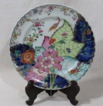 PORCELANA VISTA ALEGRE PORTUGAL - Um prato decorativo em porcelana portuguesa vitrificada branca, de coleção, luxuosamente decorado com motivos vegetalistas e zoomórficos em exuberante policromia e realces em pintura à ouro, marcado no fundo. Medida: 22 cm de diâmetro.