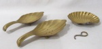 BRONZE - Três saboneteiras em bronze dourado em formato de conchas, apoiadas sobre pés bolsas, medindo: maior: comp 20 cm x larg 9 cm/ menor: comp 13 cm x larg 10 cm . Uma necessita de solda na alça. Vide fotos extras.