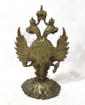 ESCULTURAS - Escultura confeccionada em bronze, ricamente cinzelado representando Águia Bicéfala. A Águia Bicéfala é um símbolo presente na iconografia e heráldica de várias culturas indo-europeias e mesoamericanas. Medidas: 24 cm de altura x 12 cm de diâmetro da base.
