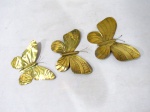 METAL DOURADO - Três borboletas para adorno de parede, confeccionadas em metal dourado, de tamanhos distintos. Medidas da maior: 16 x 23 cm/ medidas da menor: 12 x 16,5 cm.