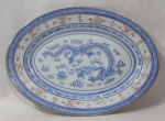 PORCELANA MADE IN CHINA - Uma travessa ovalada, de coleção, em porcelana chinesa vitrificada branca, decorada com cenas de dragão ao centro, seguido de filetes, figuras geometrizadas e elementos vegetalistas, bordas filetadas à ouro, marcada no fundo, medindo: 26 cm de comprimento x 18,5 cm de largura. Vide fotos extras.