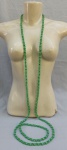BIJUTERIA, um (1) colar longo, confeccionado com contas em vidro, intercaladas, entre verde translúcido facetado e verde azulado leitoso e liso, fecho em metal prateado, faltando os apliques, medindo 2 metros.