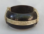 JOIA, um (1) imponente bracelete oriental, confeccionado em chifre, monture em metal prateado com ornamentação relevada em dançarinas, perolados, volutas e elementos vegetalistas, medidas internas 6,5 x 5,5 cm, largura 3,5 cm, usado, possui sinais de azinhavre.