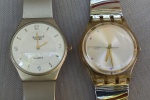 RELÓGIOS, dois (2) de pulso, distintos, ambos da marca SWATCH (fundada em 1983 por Ernst Thomke; Elmar Mock e Jacques Müller; atualmente é uma subsidiária do Grupo Swatch): 1 modelo 3359G, mostrador com algarismos arábicos, caixa em metal prateado, medindo 32 mm diâmetro, movimento quartz, pulseira em aço; 1 modelo AG 2008  910, caixa em acrílico, pulseira em aço inox (tamanho curto), ambos usados, não testados e sem garantia, possivelmente demandam nova bateria.