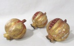 OBJETOS DECORATIVOS - Trio de romãs decorativos em madeira com pátina de folhas de ouro. Med. 10 cm de altura x 8,5 cm de largura, aproximadamente. Possui falhas na madeira e na pintura. Vide fotos.