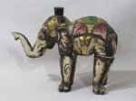 ESCULTURAS - Escultura em madeira com pátina na cor policromada, representando elefante indiano adornado com entalhes de motivos vegetalistas e realces em vasta pintura à ouro, pernas e tromba de encaixe. Medidas alt 24 cm x comp total 30 cm, aproximadamente.
