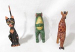 ESCULTURAS - Um gato, um sapo e uma girafa, confeccionados em madeira com pátina ricamente policromada. Medidas: maior: 24,5 cm de altura/ menor: 19 cm de altura. Vide fotos.