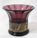 CRISTAIS - Belíssimo vaso decorativo em cristal na cor roxa, bordas moldadas em canelados, adornado com rico trabalho de cenas de festejo grego em relevo com vasta pintura à ouro. Med. alt 9,5 cm x diam 11 cm.