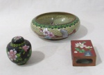 DIVERSOS - CLOISONNÉ - Um cinzeiro, um porta caixa de fósforos e um mini potiche em cloisonné, ricamente decorados com motivos vegetalistas em exuberante policromia. Medidas: maior: alt 4,5 cm x dima 9,5 cm/ menor: alt total 5,5 cm x diam da borda 1,5 cm.