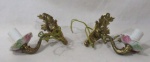 BRONZE - Par de apliques de parede para uma lâmpada em bronze dourado, ricamente cinzelado com folhas de acantos, volutas e concheados, com bobeches em porcelana vitrificada branca decoradas com flores. Med. alt 15 cm x comp 16 cm, aproximadamente. Não testados e sem garantias de funcionamento.