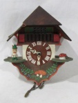 RELÓGIO - Pequeno relógio cuco de parede, confeccionado em madeira patinada em rica policromia, funcionamento à pilha, mostrador circular com numerais em algarismos romanos. Medidas: alt 20 cm x comp 15,5 cm, aproximadamente. Não testado e sem garantias de funcionamento. Possui pequena falha na madeira e falta dois pesos. Vide fotos.