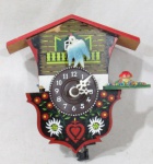 RELÓGIO - Pequeno relógio cuco de parede, confeccionado em madeira patinada em rica policromia, funcionamento à pilha, mostrador circular com numerais em algarismos indo-arábicos. Medidas: alt 11 cm x comp 10,5 cm, aproximadamente. Não testado e sem garantias de funcionamento.