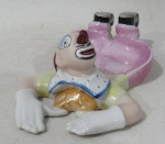 PORCELANA - Uma saboeira em porcelana ricamente policromada, moldada em formato de palhaço deitado, marcada no fundo (conforme foto extra), medindo: 17 cm de comprimento.