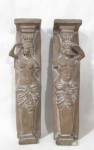 ESCULTURAS - Dois pilares de esculturas esculpidas em pedra, representando figuras Feminina e Masculina Greco Romanas. Medidas: 40 cm de altura x 9,5 cm de largura. Uma com bicado na base, conforme foto extra.