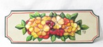 DIVERSOS - Painel decorativo de parede em madeira ricamente policromada, apresenta formato retangular com cantos chanfrados, ornamentado com belas flores e folhas em alto relevo, assinado conforme foto extra, medindo: 55 cm de comprimento x 19,5 cm de largura.