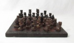 DIVERSOS - Tabuleiro para Jogo de Xadrez, em madeira nobre com bordas adornadas com entalhes com elementos vegetalistas, com suas as respectivas peças, sendo dezesseis (16) na cor preta e dezesseis (15) na cor marrom. Medidas do tabuleiro: 33 cm de largura. Com sinais de uso.