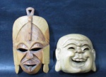 ARTE AFRICANA - Duas máscaras esculpidas em madeira, sendo uma de figura Africana Tribal (marcada MADE IN KENIA), e uma de Buda Hindu. Medidas: maior: 20,5 cm de altura/ menor: 12,5 cm de altura. Vide fotos.