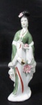 ESCULTURAS - MADE IN CHINA - Escultura em porcelana oriental vitrificada branca, com esmaltagem em rica policromia e realces à ouro, ricamente detalhada, representando "Gueixa", ornada com flores em alto relevo, marcada no fundo. Med. 30,5 cm de altura. Vide fotos!