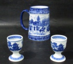 PORCELANA - Dois porta ovos porchê e uma caneca em porcelana oriental vitrificada nas tonalidades branca e azul cobalto, com rica ornamentação de motivos vegetalistas, cenas de pagode chinês e do cotidiano. Medidas: maior: alt 13 cm x diam 7,7 cm/ menor: alt 6,8 cm x diam 4,5 cm. Caneca marcada DUO CAI MADE IN CHINA em sua base.