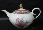 PORCELANA SCHMIDT - Um bule para chá em porcelana vitrificada branca, decorado com motivos florais em rica policromia ao centro, seguido de bordas adornadas com guirlandas de folhas e arabescos, generosos filetes e gregas em pintura à ouro, sobre faixa esmaltada na tonalidade rosa, pega da tampa em forma estilizada,  alça vazada e bico arrematados com vasta douração, marcado no fundo. Med. alt total 16,5 cm x larg total 30,5 cm. Em ótimo estado!