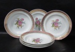 PORCELANA SCHMIDT - Seis pratos rasos em porcelana vitrificada branca, decorados com motivos florais em rica policromia ao centro, seguido de bordas adornadas com guirlandas de folhas e arabescos, generosos filetes e gregas em pintura à ouro, sobre faixa esmaltada na tonalidade rosa, marcados no fundo. Med. 24,5 cm de diâmetro. Um com fio de cabelo ínfimo bicado na borda, conforme foto extra.