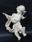 ESCULTURA - Graciosa escultura para adorno de parede, confeccionada em resina policromada, ricamente detalhada, representando "Anjo Musicista". Medida: 25 cm de altura, aproximadamente.
