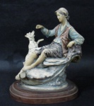 ESCULTURAS - Belíssima escultura em resina italiana, ricamente detalhada e policromada, representando "Menino sentado em pedra com seu cachorro", sobre base de madeira em formato oval, assinatura não identificada. Medidas alt 20,5 cm x comp da base 16,5 cm x larg da base 12 cm. Possui um bicado na parte inferior da pedra.