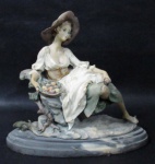 ESCULTURAS - Belíssima escultura em resina italiana, ricamente detalhada e policromada, representando "Leide sentada segurando cesta de frutos", sobre base ovalada escalonada, assinatura não identificada. Medidas alt 23 cm x comp da base 25,5 cm x larg da base 11 cm.