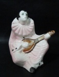 ESCULTURAS - Delicada escultura em faiança vitrificada e policromada representando "Pierrot", medindo: 17 cm de altura x 13,5 cm de comprimento da base.