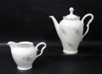 PORCELANA CONDESSA BLUMENAU - Um bule para café e uma cremeira em porcelana nacional com esmaltagem branca, delicadamente decorados com elementos vegetalistas em policromia, arrematados com filetes em pintura à ouro, pega da tampa e alças vazadas em formas estilizadas, marcados no fundo. Med. bule: alt total 18,5 cm x larg total 18,5/ cremeira: alt 9,5 cm x larg total 14 cm. Bule com ínfimo bicado na base.