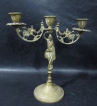 CANDELABRO / CASTIÇAL - Castiçal para três velas em bronze, ricamente cinzelado, braços ornamentados com folhas, coluna com escultura de figura feminina, seguido de base circular, medindo: alt 23,5 cm x diam da base 9,5 cm.