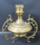 ABAJUR - Um pé de abajur em metal dourado, ricamente cinzelado, corpo ornamentado com arabescos relevados circundantes, apoiado sobre três pés curvos elevados ricamente trabalhados em volutas, medindo: alt 35,5 cm x 30 cm de largura, aproximadamente. Não acompanha fiação e cúpula.